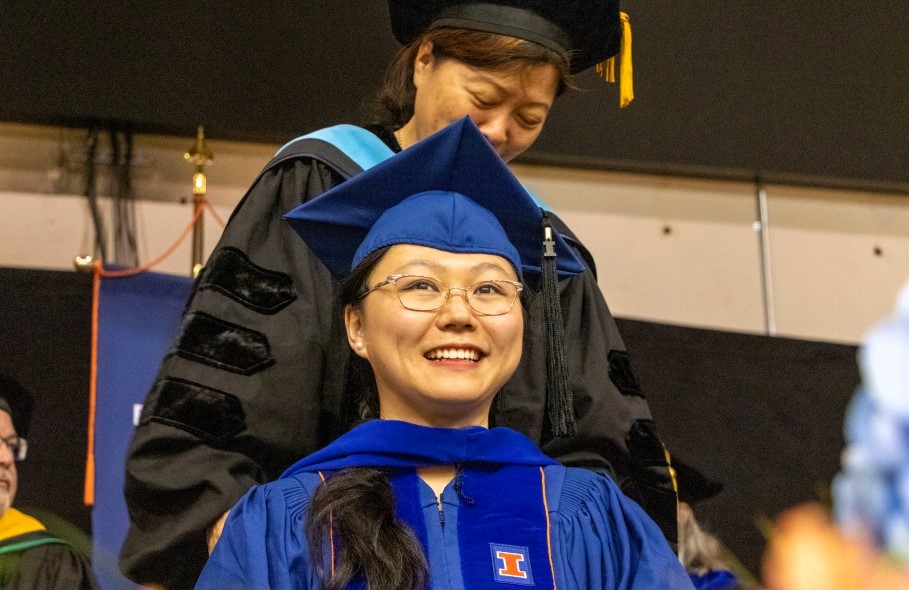 Professor Jessica Li hoods a doctoral student at Convocation.