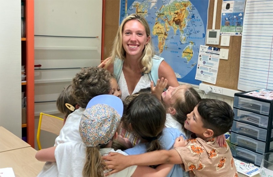 Grace Schlichter with young students in a French classroom
