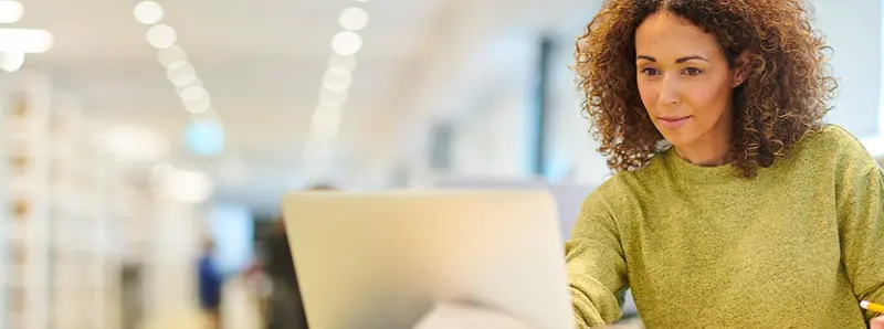 Woman working on laptop in the library