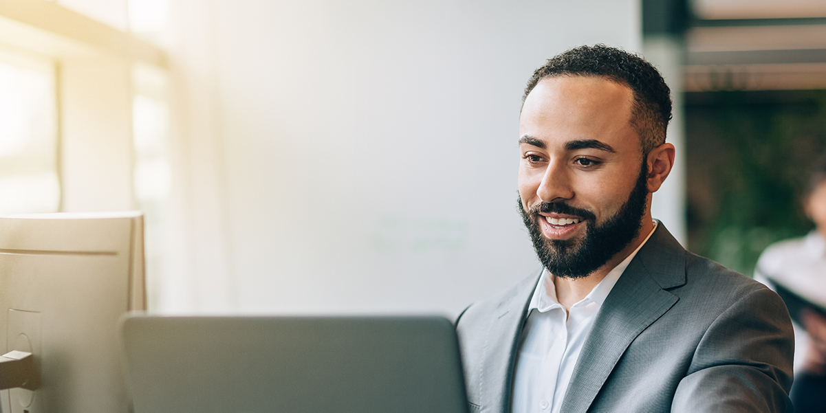 Man smiling while working on computer in office