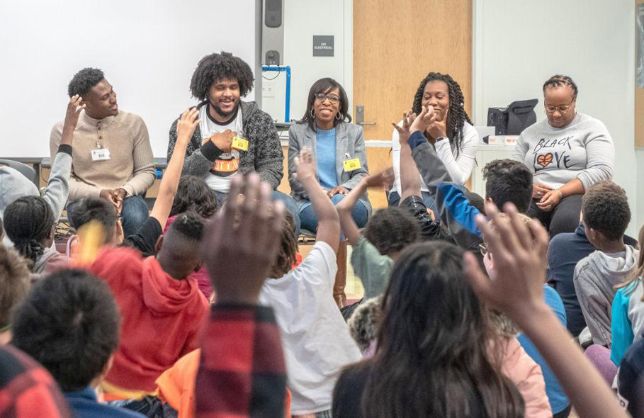 Members of the Education's Office of Community College Research and Leadership talk to students at BTW STEM Academy. 