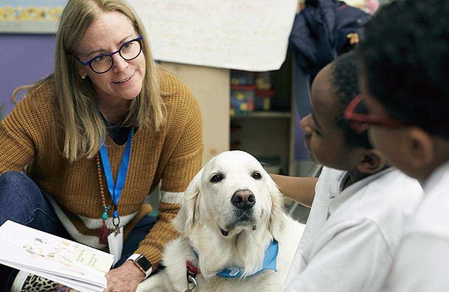 Rebecca Cline and dog Ajax help students read