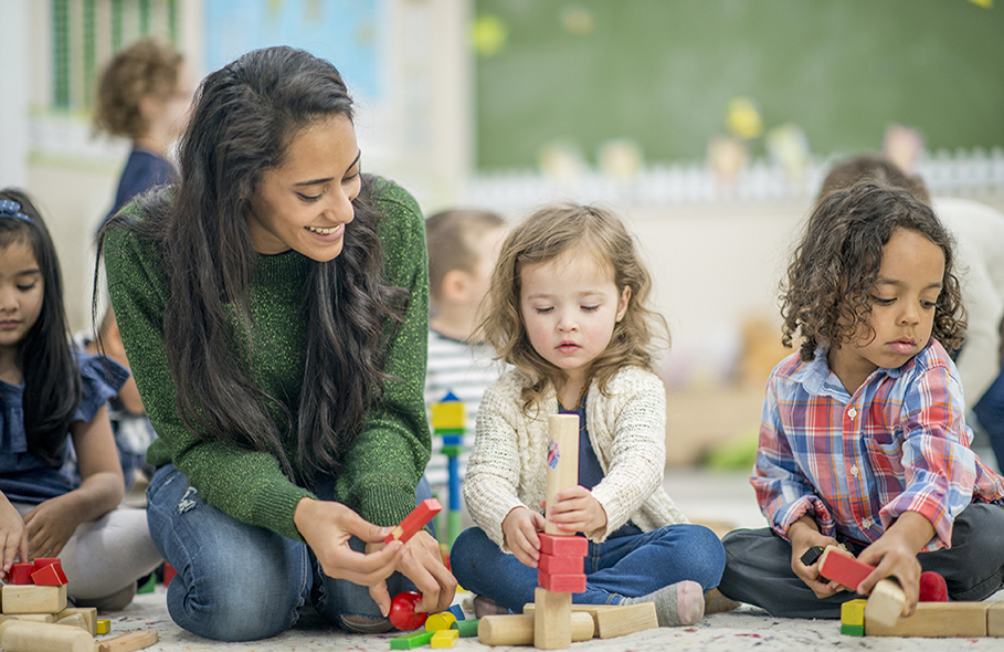 teacher and students using building blocks in Pre-K classroom