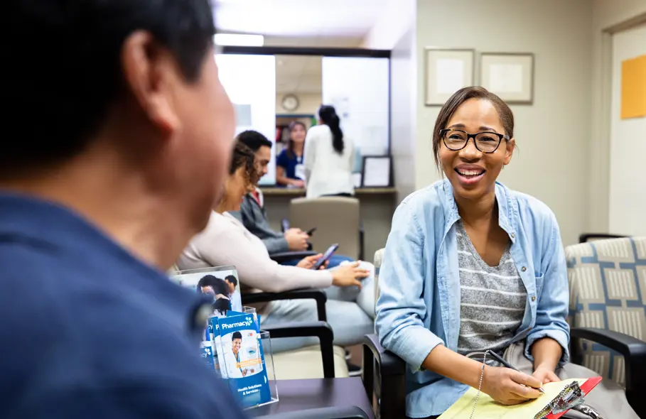 black female patient smiling in a doctor's office waiting room