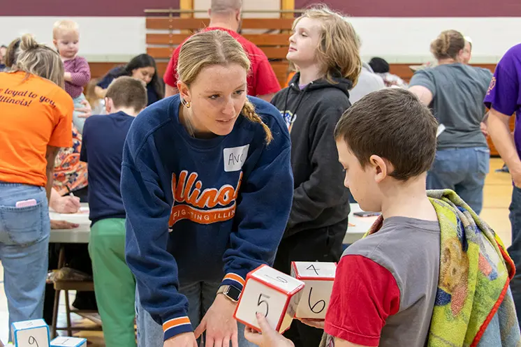 pre-service teacher talks to a student about a math game