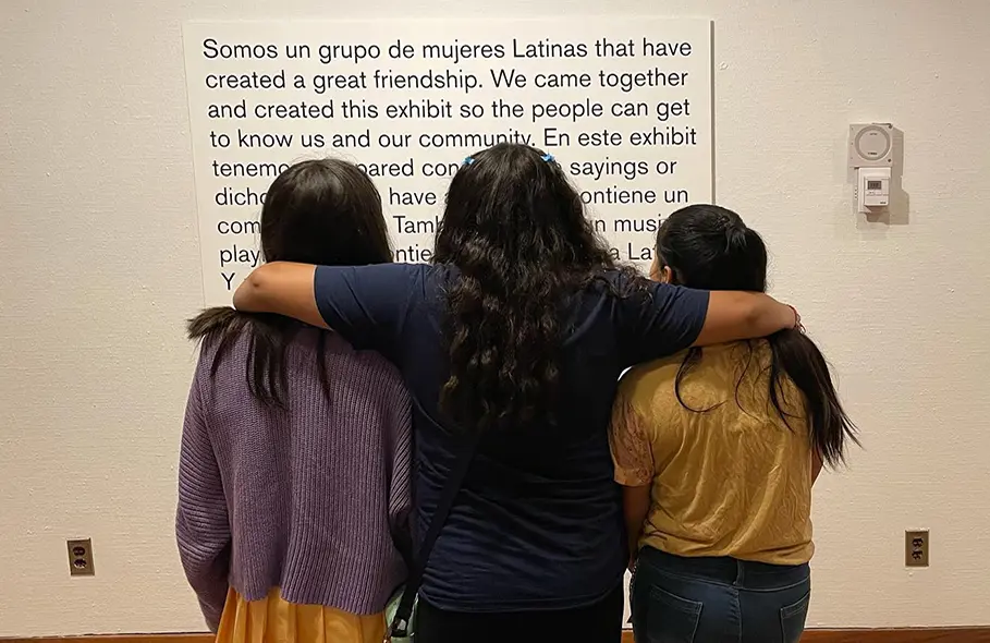 Latina students stand in front of their exhibit
