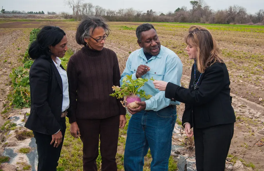 Mildred Griggs talking with others on a farm