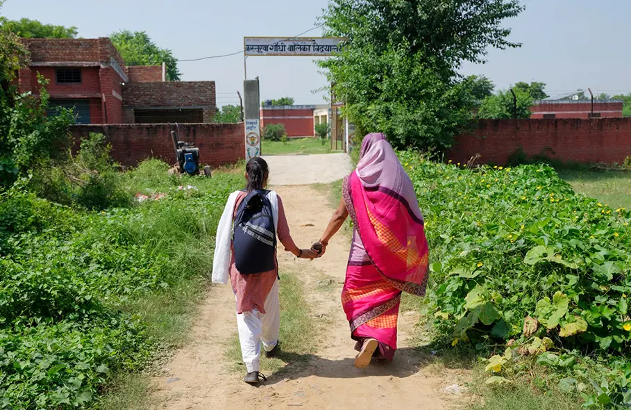 student and mother walking to school in India